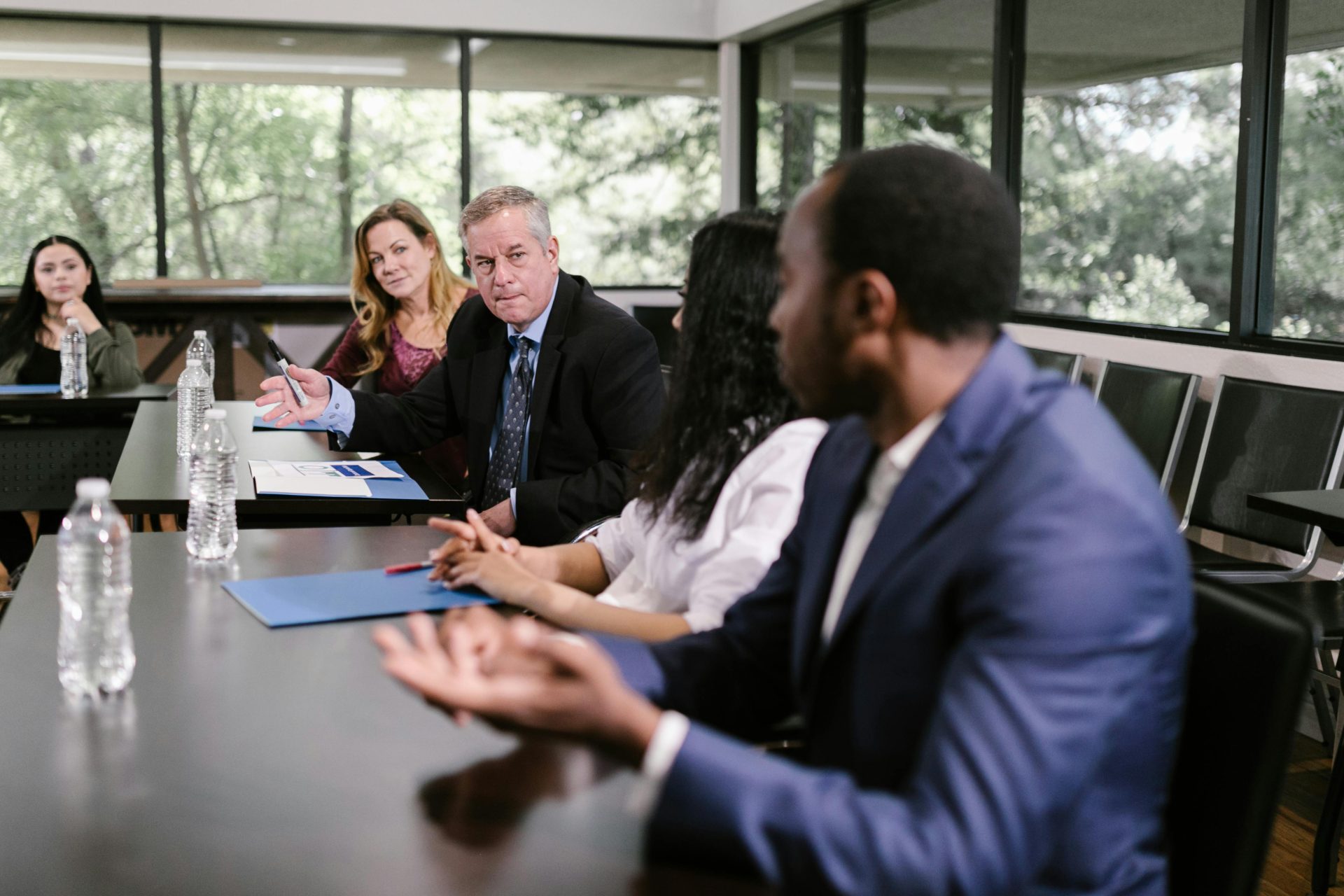 A diverse group of professionals engaging in a collaborative meeting in a conference room setting.
